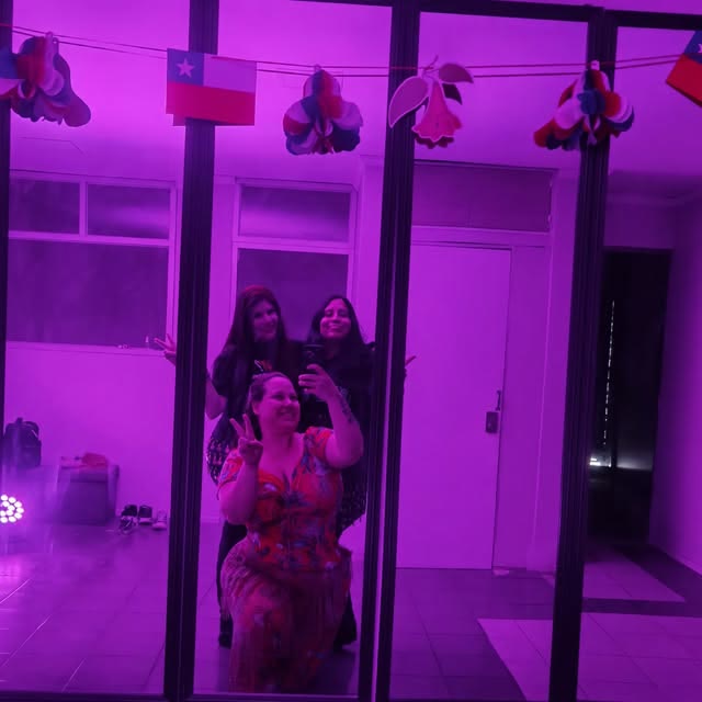 Sala de clases con luz rosada y banderines de Chile
